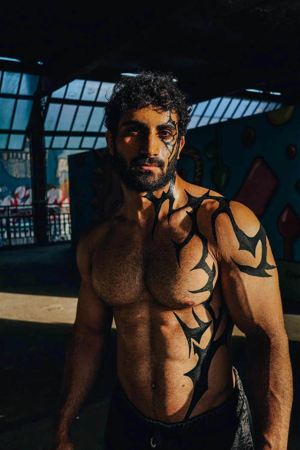 Body-paint editorial shot against a painted wall.